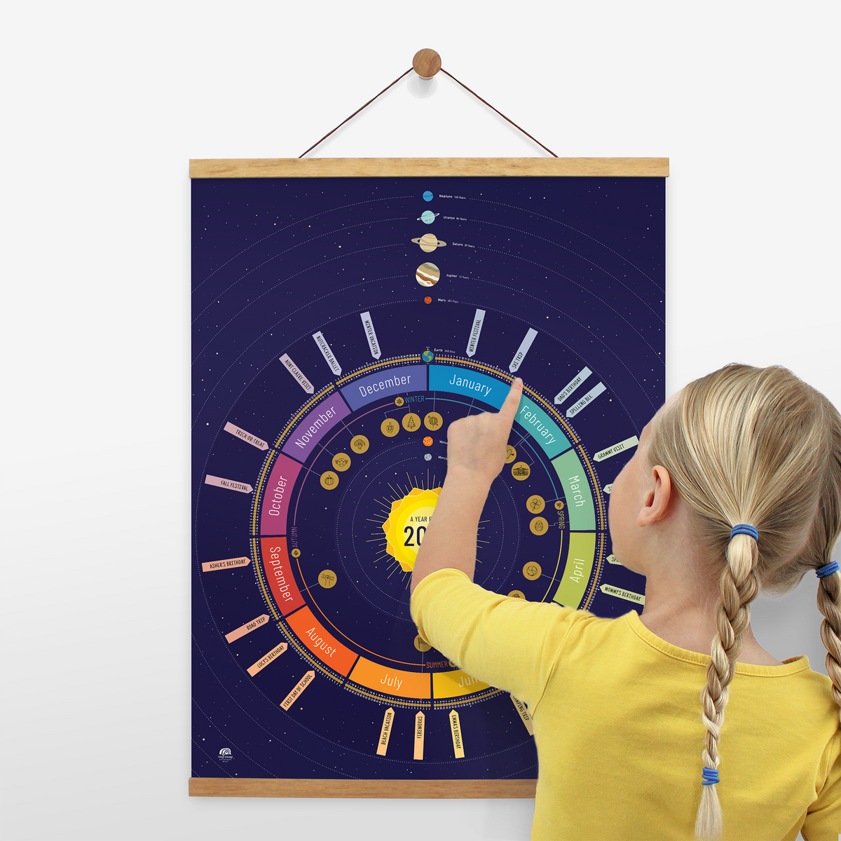 Child using the Space (navy) Year Round Calendar to count down days until their birthday. Displayed on the wall with a wooden poster hanger.