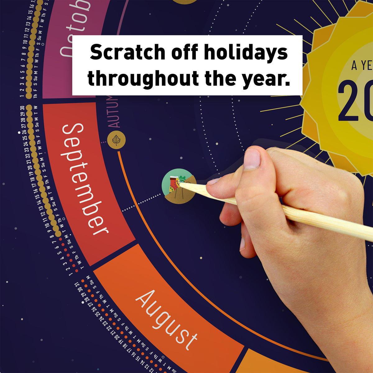 Hand scratching off a holiday icon on the Space (navy) Year Round Calendar (With Holidays version) to reveal colorful artwork underneath.