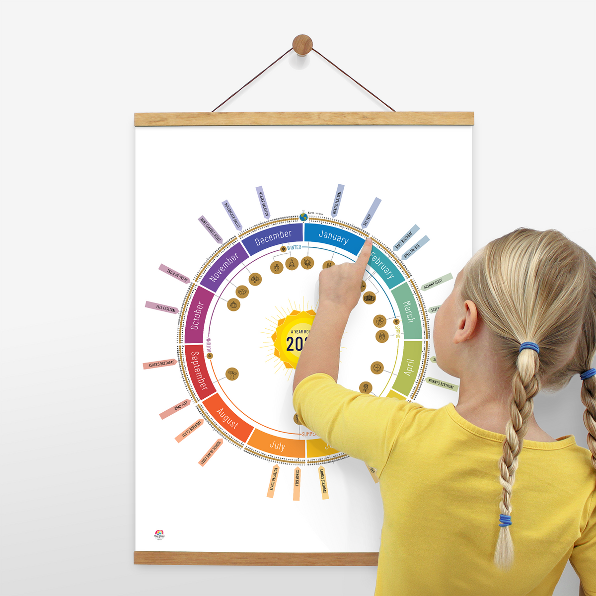Child using the White Year Round Calendar to count down days until their birthday. Displayed on the wall with a wooden poster hanger.