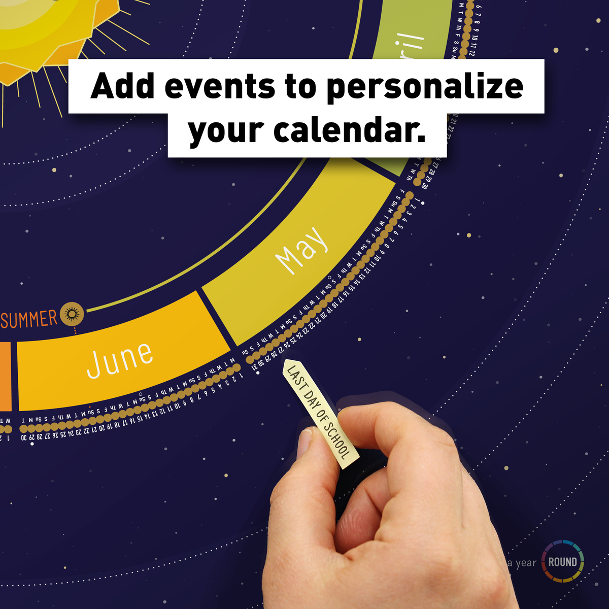 Hand adding a sticker flag to personalize the Space (navy) Year Round Calendar with important events.